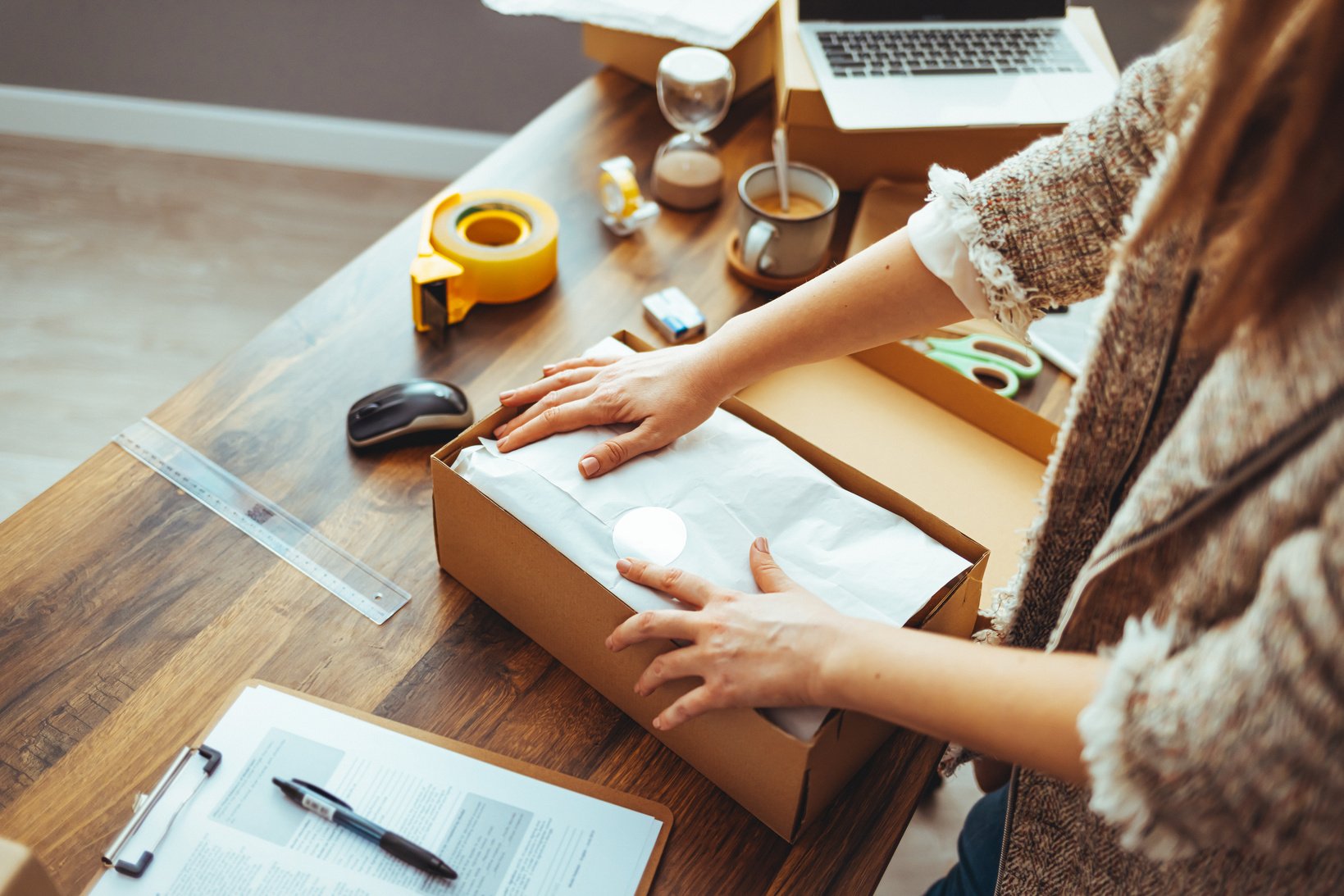 Owener of small business packing product in boxes, preparing it for delivery