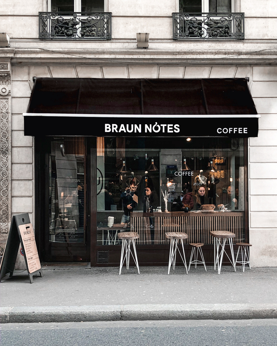 Exterior of stylish coffee shop with glass wall and street terrace